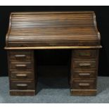 An early 20th century oak twin pedestal roll top desk