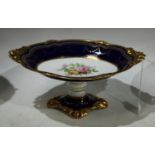 A Royal Crown Derby shaped oval comport, acorn handles, blue and gilt banded border with panel of