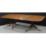 A George III style mahogany rounded rectangular twin pillar dining table, one additional leaf,