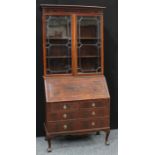 A 'Geroge III' mahogany bureau bookcase, dentail cornice above a pair of glazed doors enclosing