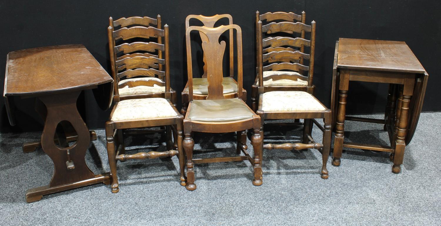 An oak oval gateleg dining table and four oak ladder back dining chairs; an oak oval drop leaf