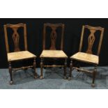 A set of three elm rush seat cottage chairs, shaped cresting rails, pierced slats, early 19th