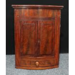 A Georgian flame mahogany bow front corner cabinet