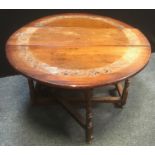 An oak drop leaf table, oval top, carved floral band, turned legs. 70cm high x 113cm wide x 42cm