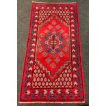 A Turkish woollen rug, central medallion within shaped field, surrounded by double multi tone