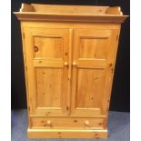 A modern pine gentleman?s low wardrobe, three quarter gallery to top, two panel doors over long