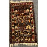 An Antique Persian Balouch type prayer rug, central panel of two temples and gardens, within two