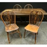 A rectangular oak refectory style dining table and matched set of four wheel back chairs, 168cm x