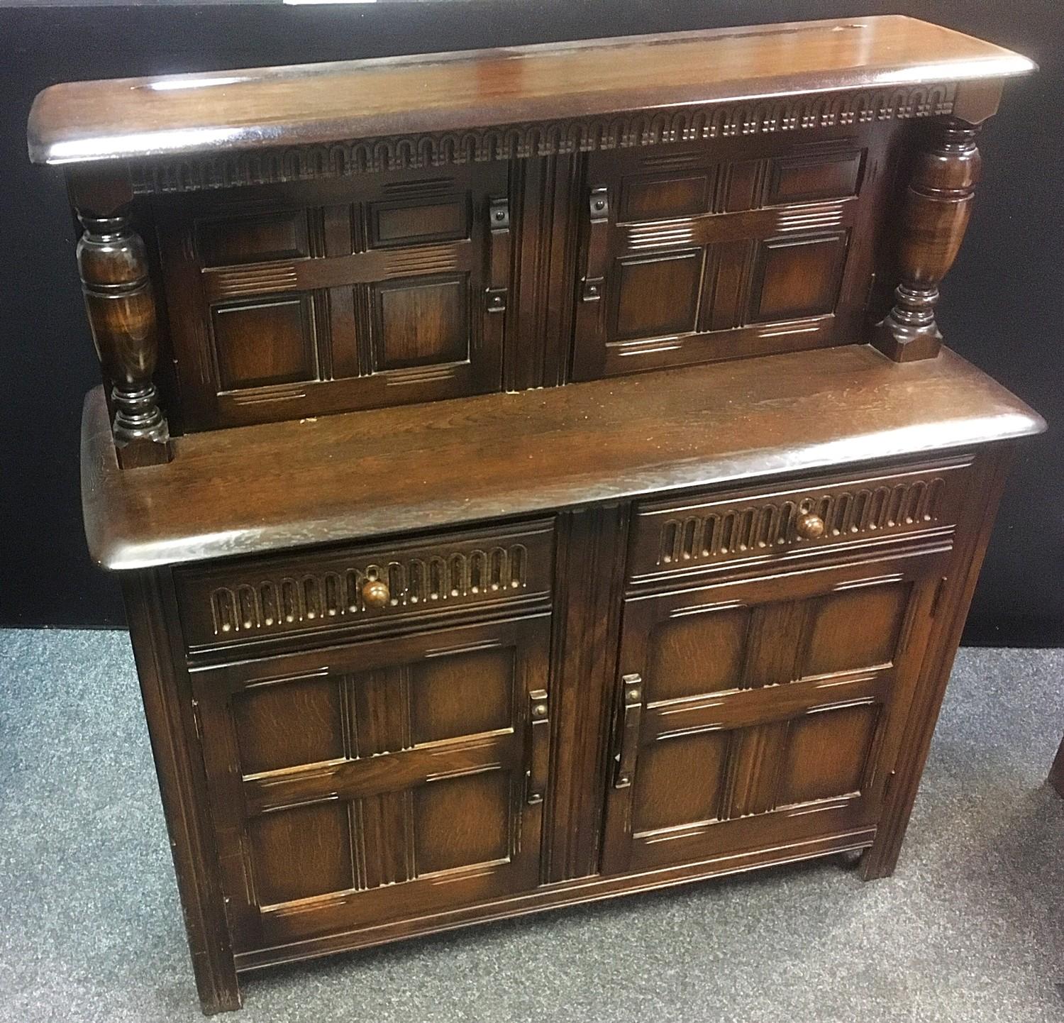 An oak court cupboard, two panel doors flanked by turned columns to top, two nulled front drawers