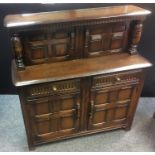 An oak court cupboard, two panel doors flanked by turned columns to top, two nulled front drawers