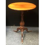 A William IV mahogany tilt-top tripod table, dished top, baluster column, hipped sabre legs. 74.