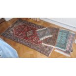 A Middle Eastern woollen rectangular rug, 148cm x 74cm; four small woollen mats, 55cm x 32cm;