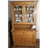 A 19th century pine dresser, moulded cornice, above two glazed cupboard doors, the projecting base