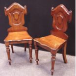 A pair of Victorian mahogany hall chairs.