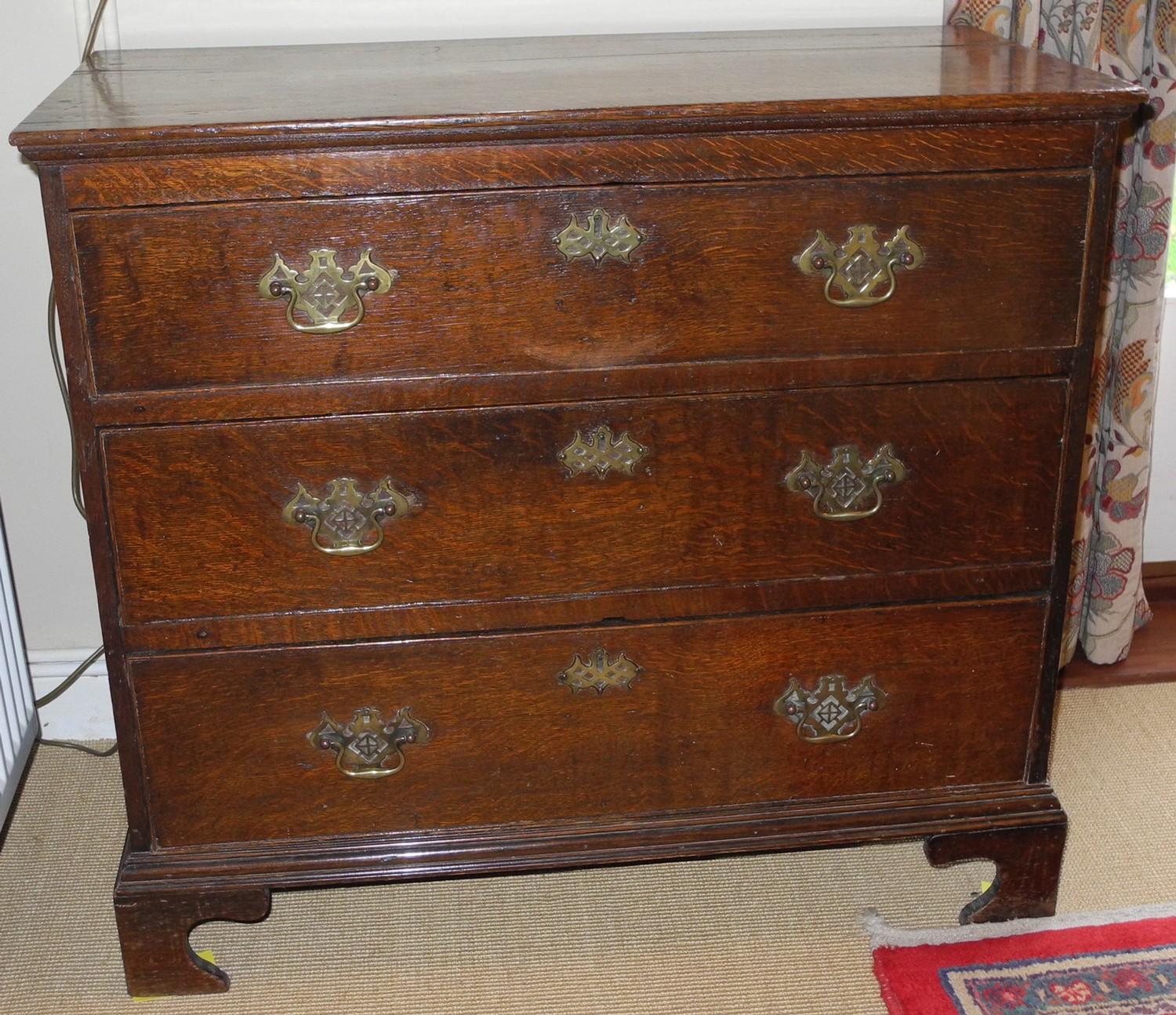 An 18th century oak chest, of three long drawers, pierced batwing handles and escutcheons, 80cm