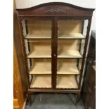 An Edwardian mahogany two door display cabinet, arched top, frieze decorated in relief, twin