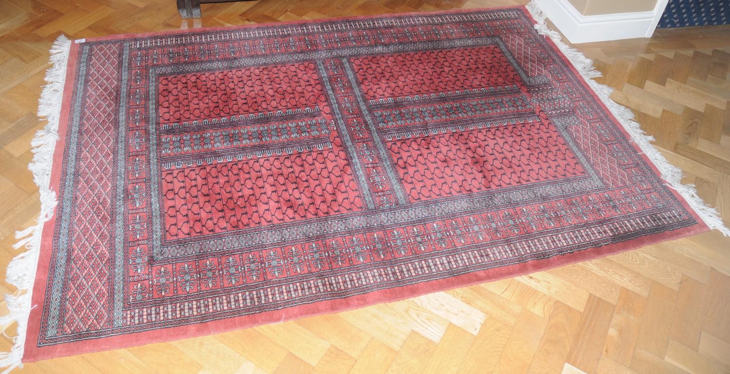 A Middle Eastern woollen rug, woven with geometrical panels, 188cm x 130cm