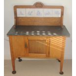 An early 20th century oak washstand, with four tiles to splash back, marble top, single door,