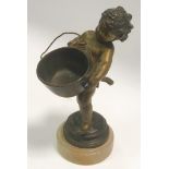A late 19th century patinated bronze figure, young child carrying a jam pan, stepped alabaster