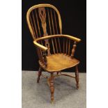 An ash and elm Windsor chair, shaped and pierced splat, saddle seat, crinoline stretcher.