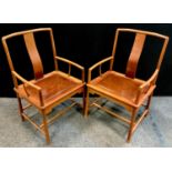 A pair of contemporary teak open arm chairs, shaped plain rail, arched splat, paneled seat above