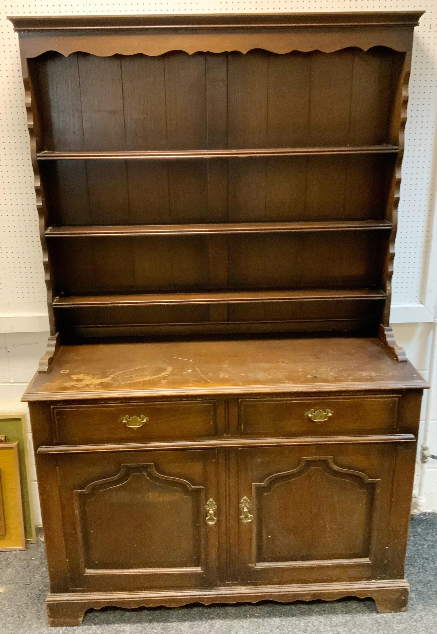 An oak dresser shaped uprights, two drawers over two panel doors to base