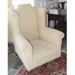A 20th century wingback chair, high back, turned legs, casters