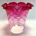 An Early 20th century cranberry glass lamp shade, tapering crosshatched body, wavy rim, front 26cm