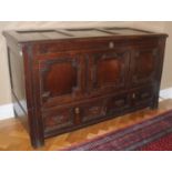 An 18th century oak blanket chest, with panelled top, above field panelled front and two drawers,
