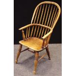 An ash and elm Windsor chair, pierced and shaped splat, saddle seat, crinoline stretcher.