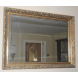 A contemporary rectangular mirror, the frame moulded with scrolls, 84cm wide, 60cm high