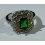 An Art Deco style base metal dress ring, green and clear glass stones, size P, boxed