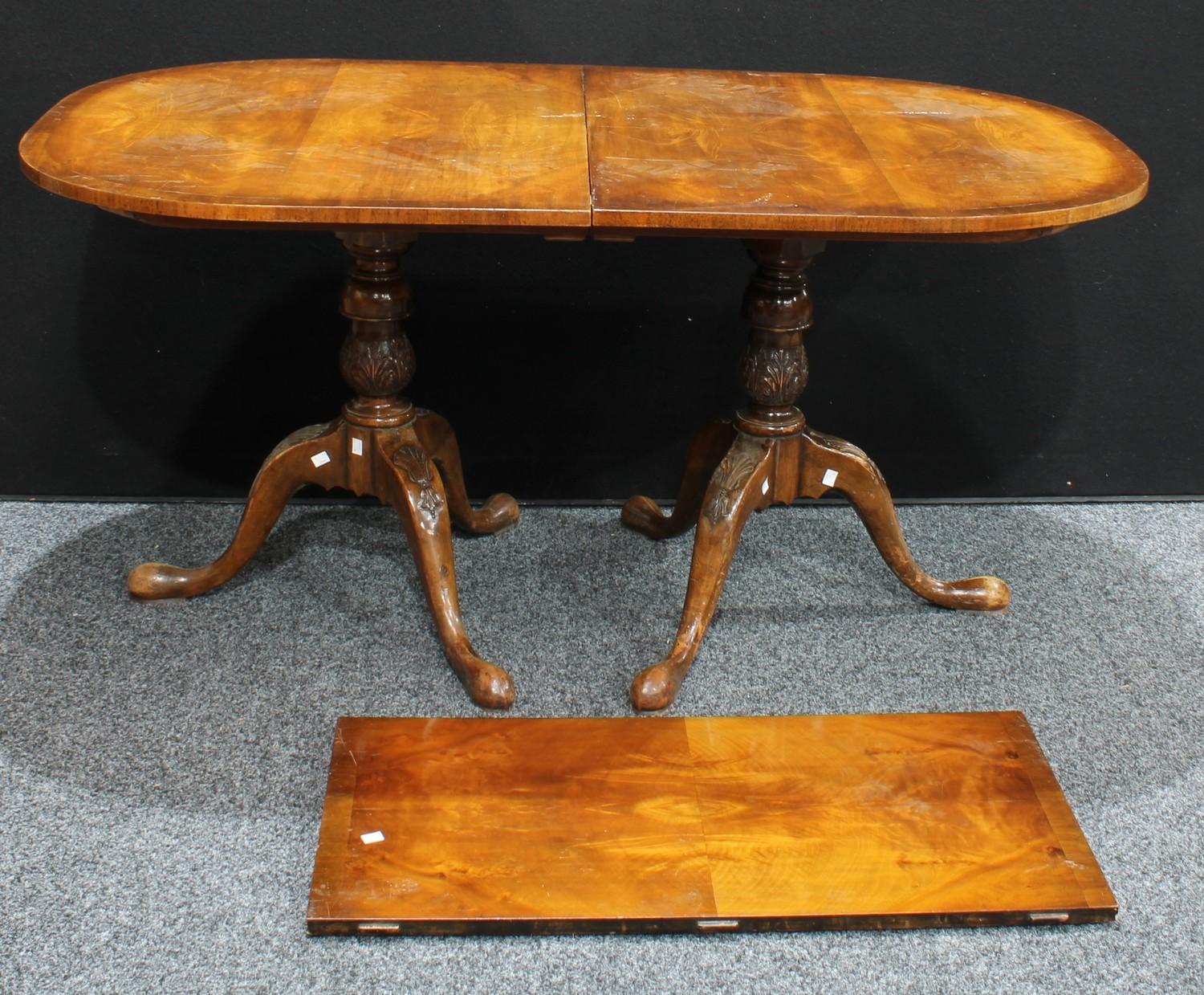 A George III style mahogany dining table, oval top, carved twin pedestals, one additional leaf, 74cm