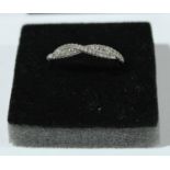 A white metal crossover ring, set with white stones, marked 14k (not tested), ring size P1/2, 2.49g