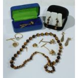 A tiger's eye single strand of polished graduated beads, a pair of droplet earrings en suite; a pair