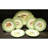 A Limoges fish service, comprising oval serving plate and twelve fish plates, transfer printed