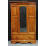 A Edwardian mahogany single wardrobe, outswept cornice above a rectangular bevelled mirror door, the