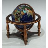 A desktop globe inset with geological specimens and mother of pearl, approximately 23cm high