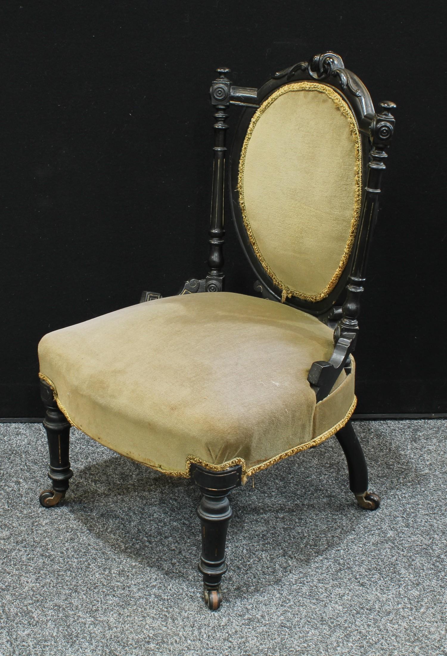 An Aesthetic Movement ebonsied low salon chair, stuffed-over oval back crested by scrolling - Image 2 of 4