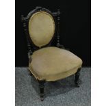 An Aesthetic Movement ebonsied low salon chair, stuffed-over oval back crested by scrolling