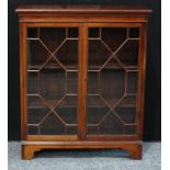 A mid 20th century mahogany bookcase, rectangular top above a pair of astral glazed doors