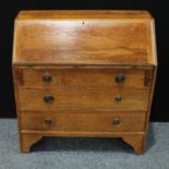 A 20th century oak bureau, fall front enclosing an arrangement of pigeon holes and two small drawers