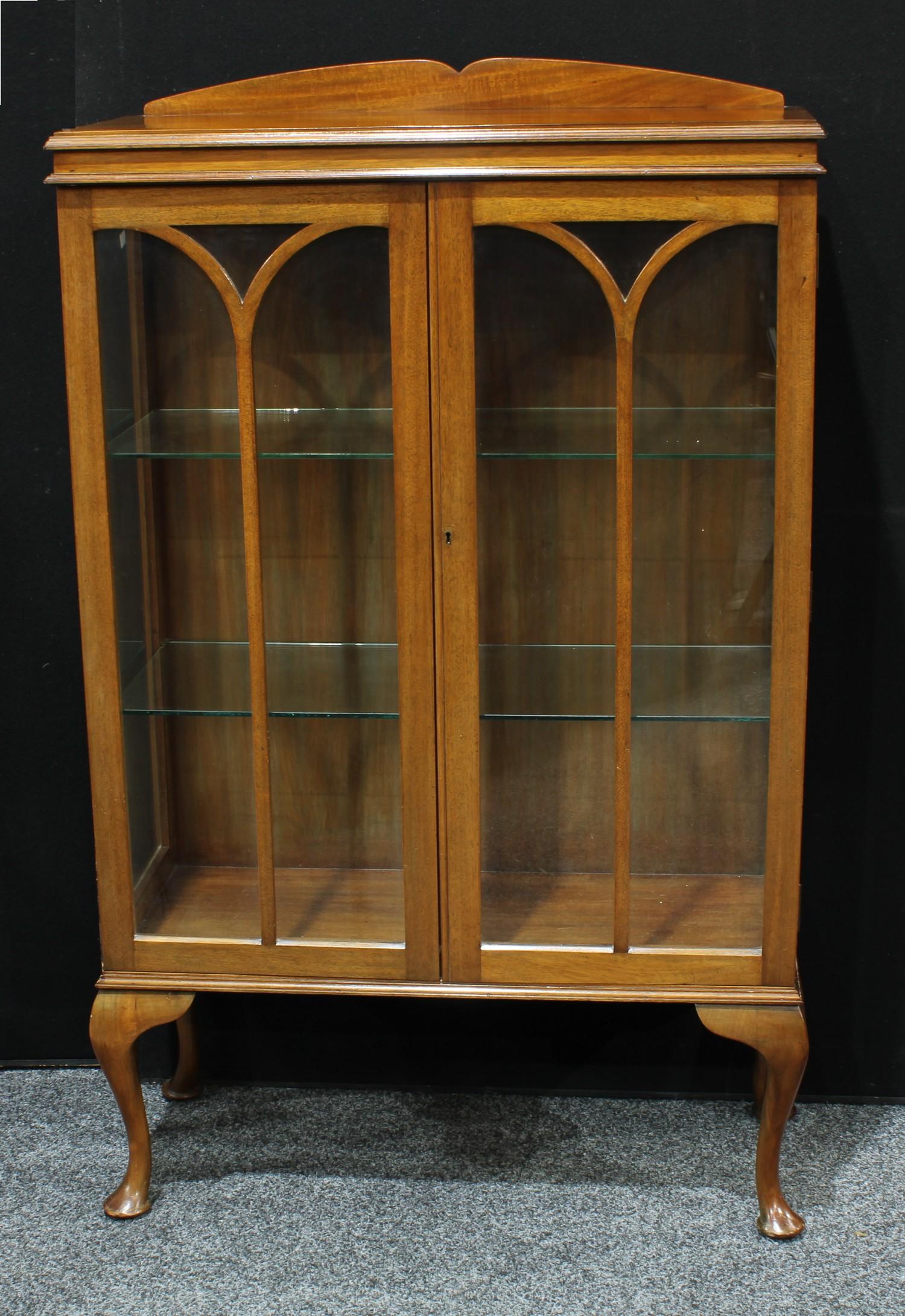 An Art Deco period walnut display cabinet, shaped half gallery above a pair of glazed doors