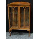 An Art Deco period walnut display cabinet, shaped half gallery above a pair of glazed doors