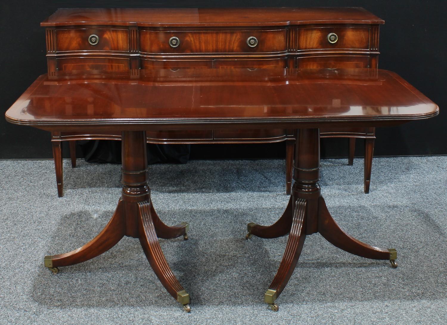 A reproduction Regency style twin pedestal mahogany dining table, rounded rectangular top, reeded