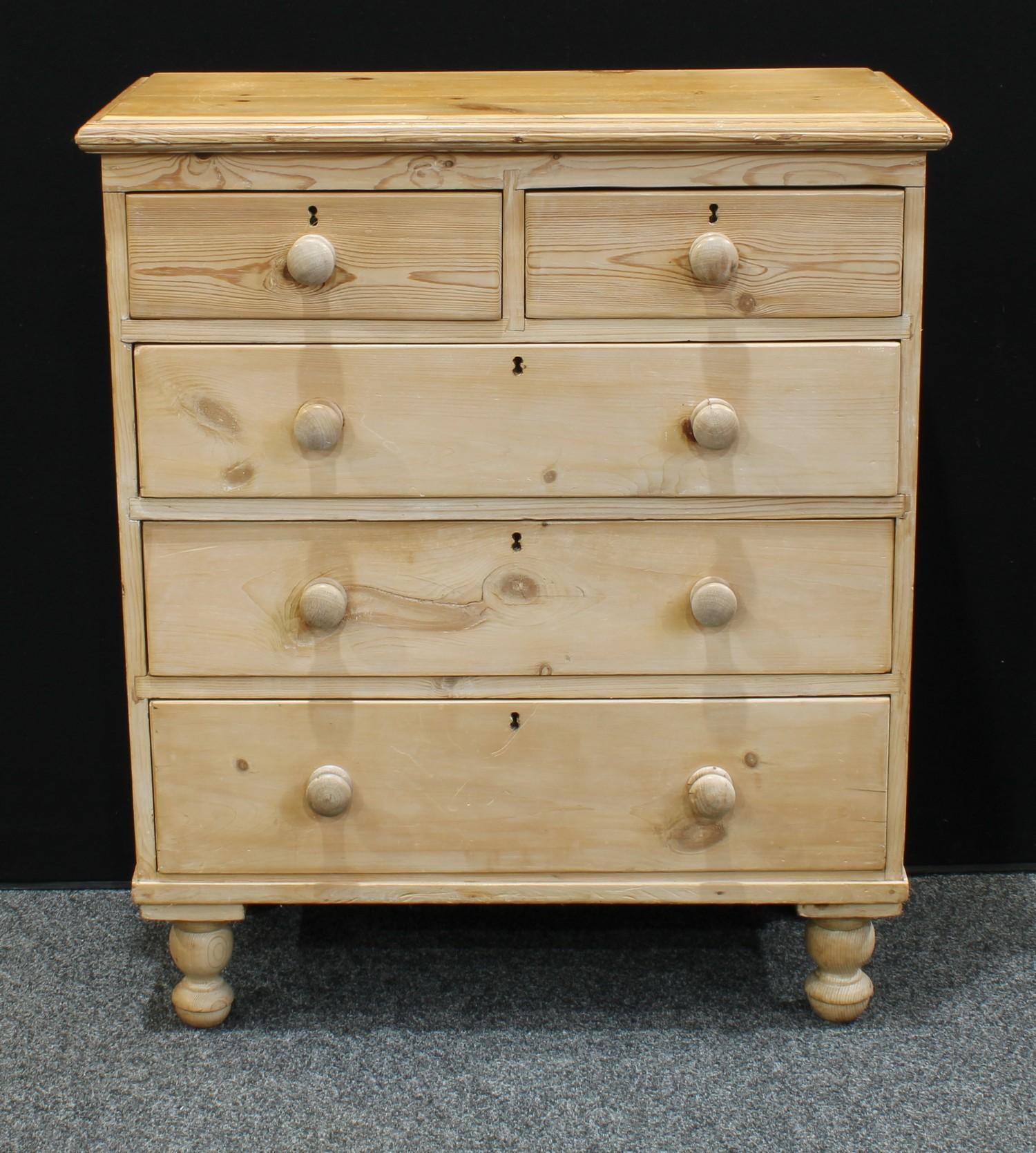 A farmhouse pine chest of drawers, oversailing rectangular top above two short and three long