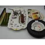 Mixed lot to include 2 Goebel Hummel figures, ornate sugar tongs, beermats, tire ashtray, pen set,