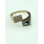 A contemporary design 18ct. gold aquamarine and diamond ladies ring, size N, 5.88 grams