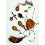 A collection of amber and amberoid jewellery includes heart shaped brooch, earings pendants and
