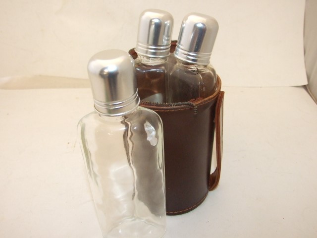 TRIO OF GLASS HIP FLASKS IN A FAUX? LEATHER CASE